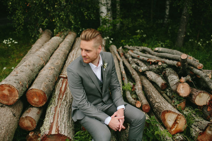 groom sitting on logs