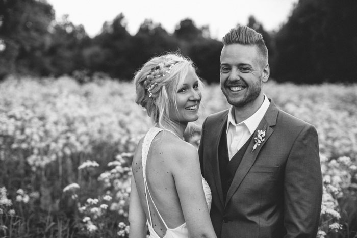 bride and groom smiling in meadow