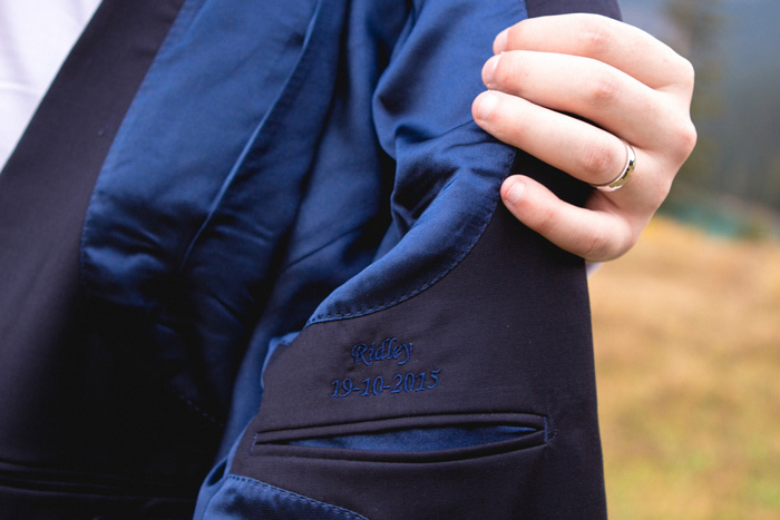 groom showing off custom embroidery inside suit jacket