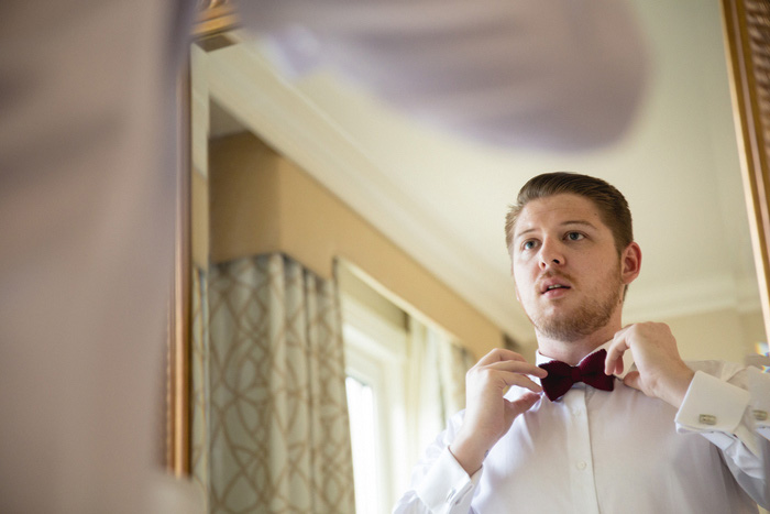 groom adjusting bow tie