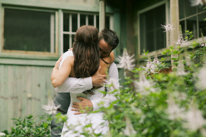 bride and groom hugging outside cottage