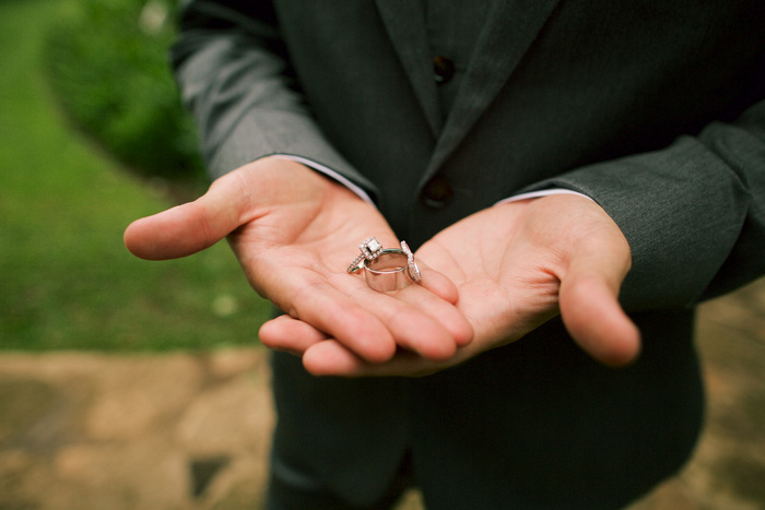 close-up of groom holding rings