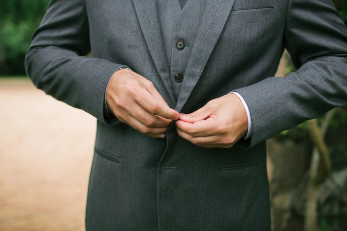 groom buttoning jacket