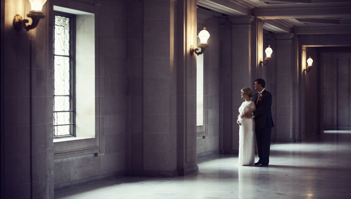 bride and groom portrait looking out window