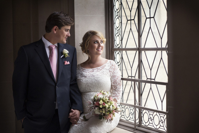 bride and groom portrait looking out window