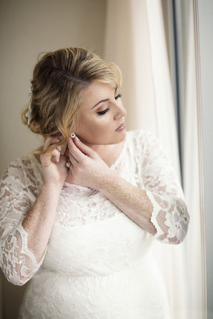 bride putting on earrings