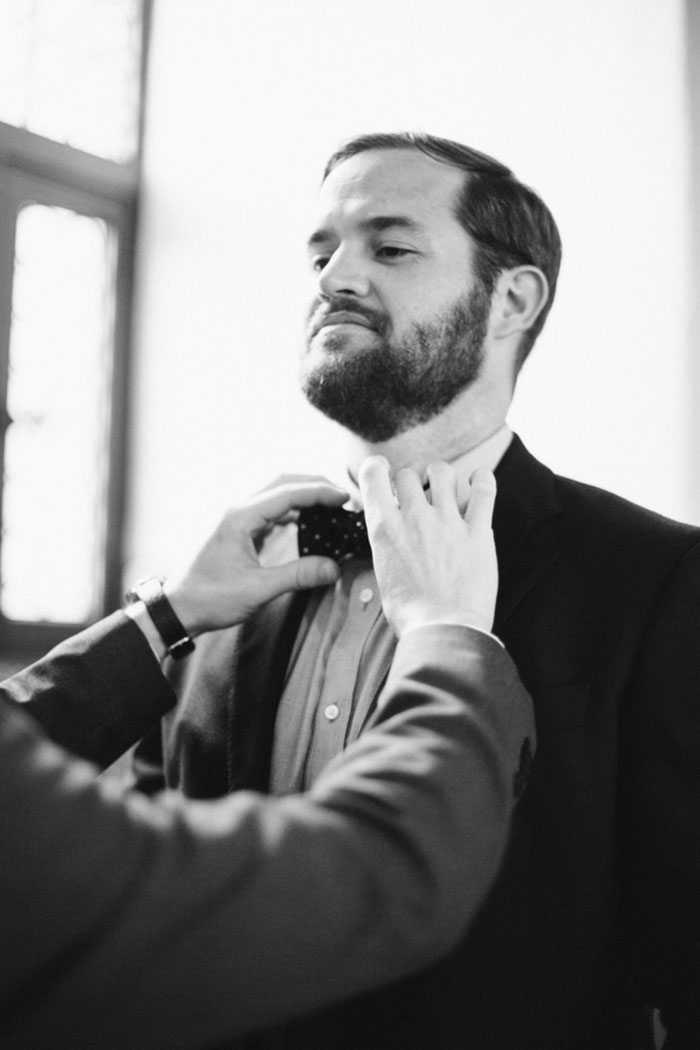 groom having bow tie adjusted