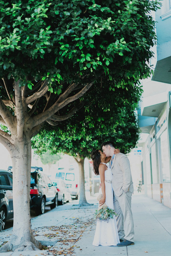 bride and groom kissing in San Francisco street