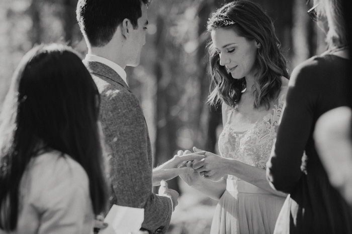 bride putting ring on groom's finger