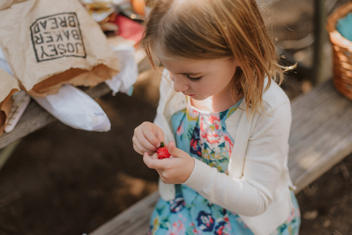 child eating strawberry