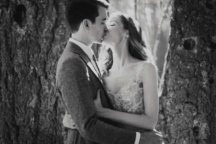 bride and groom kissing in the woods