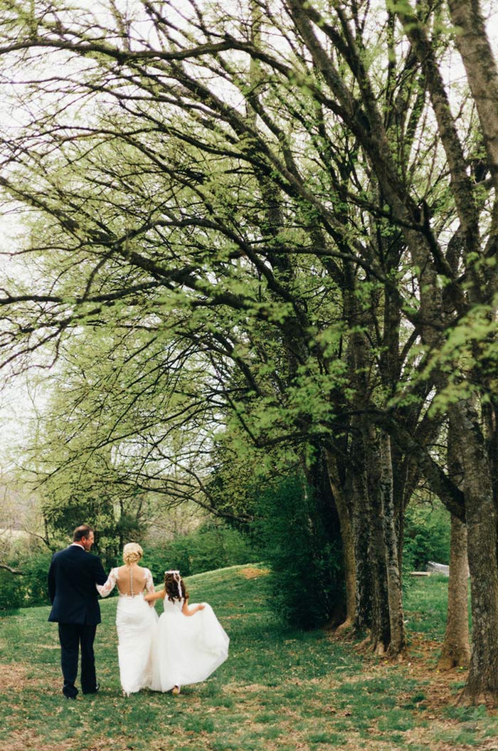 bride and groom walking with daughter