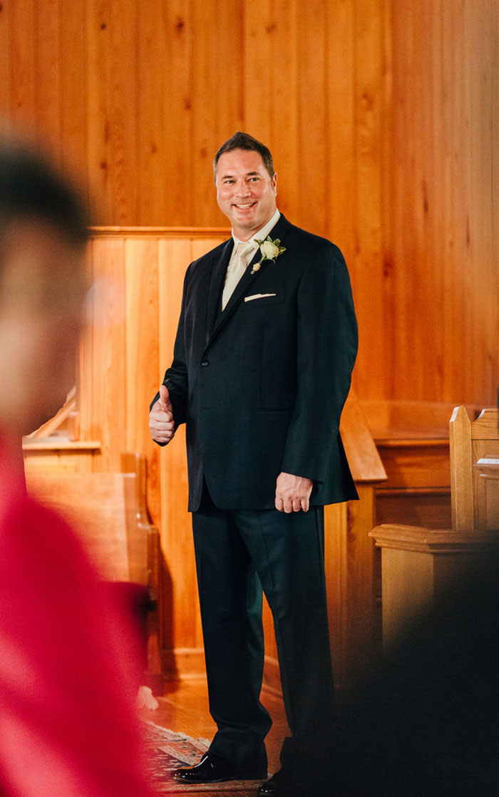 groom standing at the altar giving thumbs up 