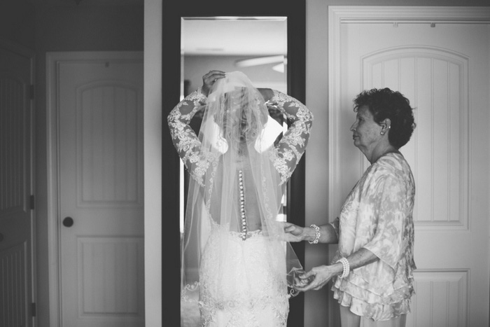 bride adjusting her veil in the mirror