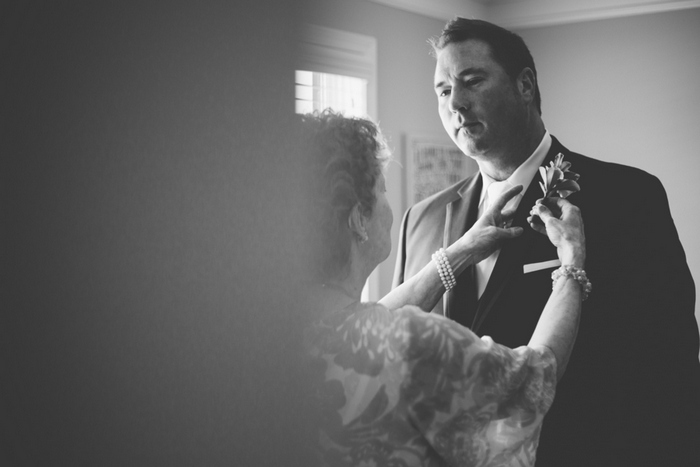 groom having boutonniere pinned on