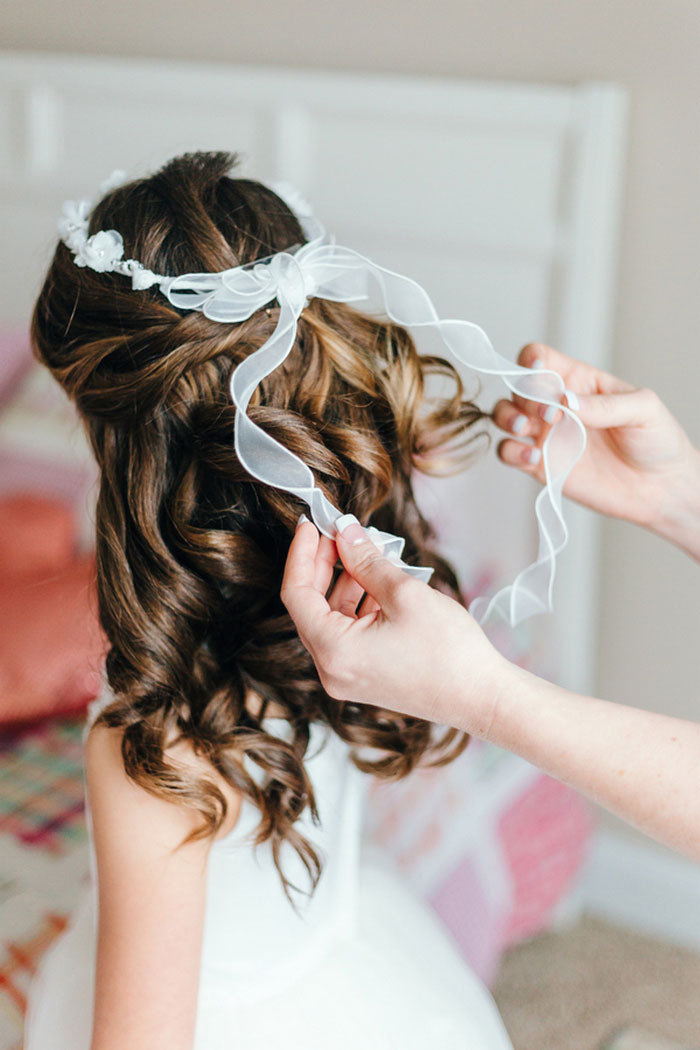 floewer girl having ribbon put in hair