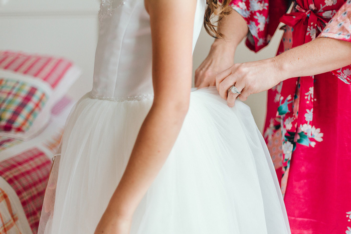 flower girl getting zipped into dress