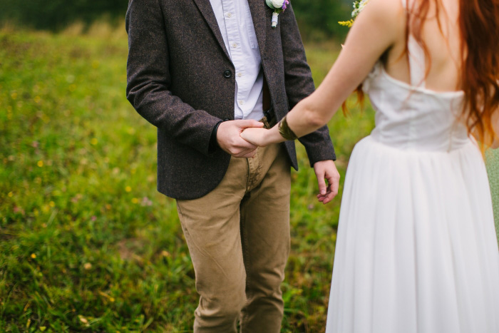 groom holding bride's hand during ceremony