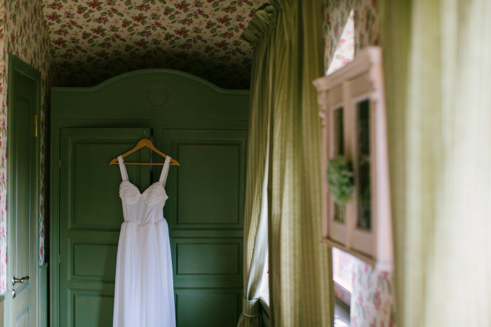 wedding dress hanging up on armoire