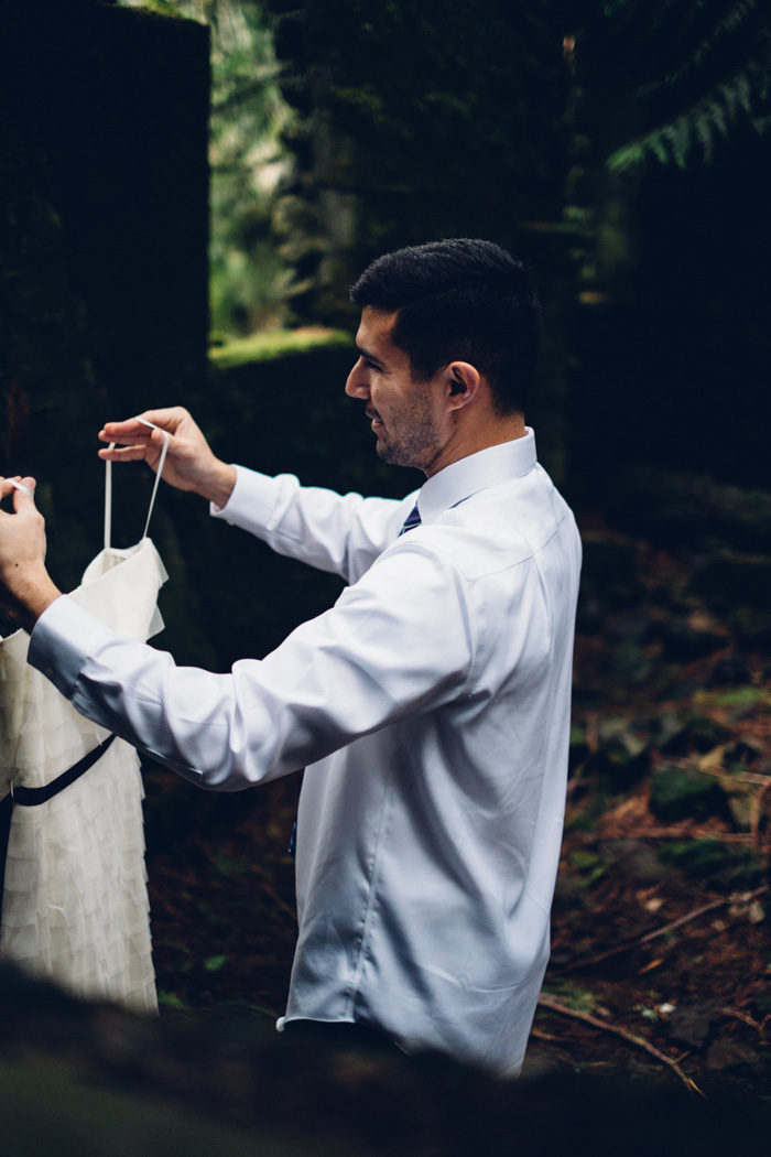 groom carrying wedding dress