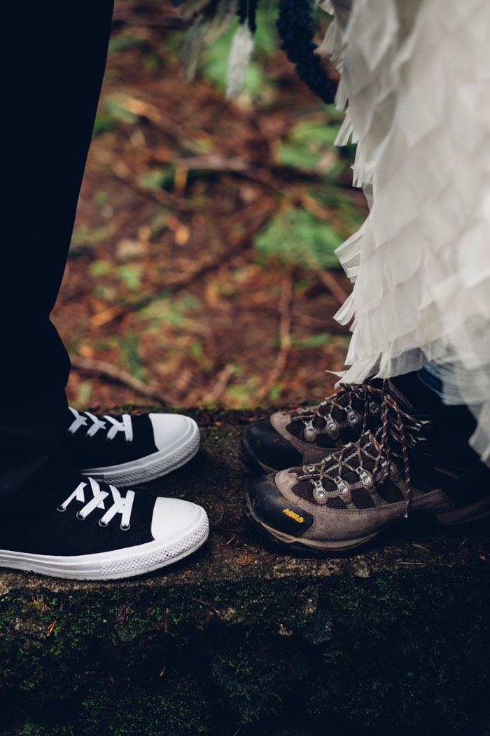 photo of groom's sneakers and bride's hiking boots