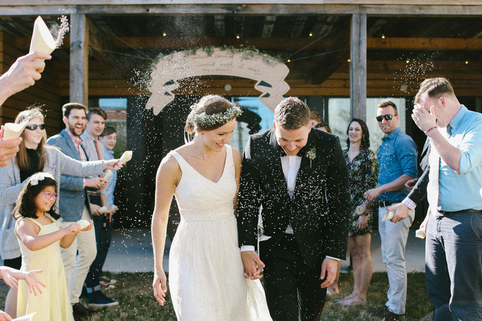 guests throwing lavender confetti on bride and groom