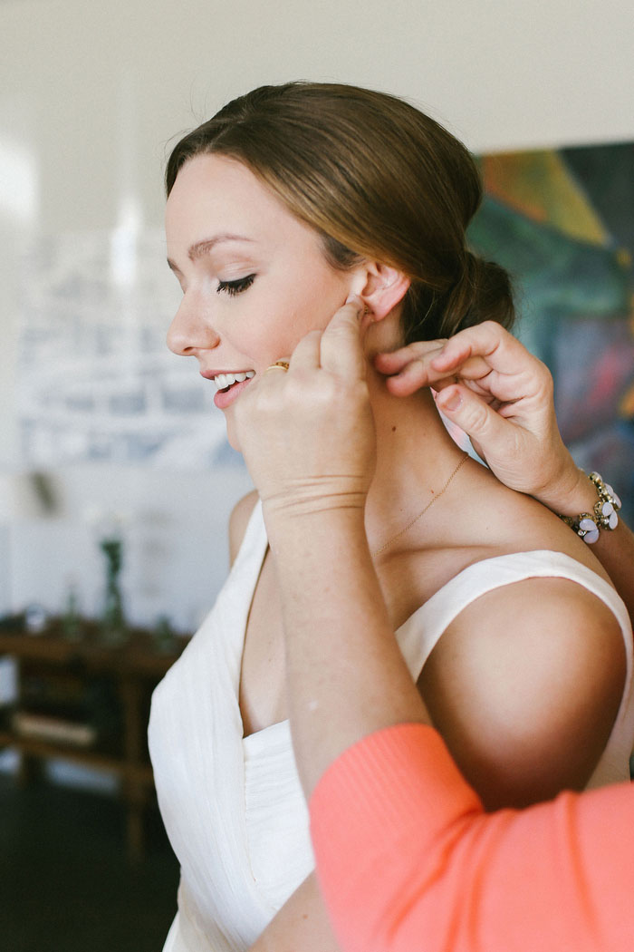 bride having her earrings put on