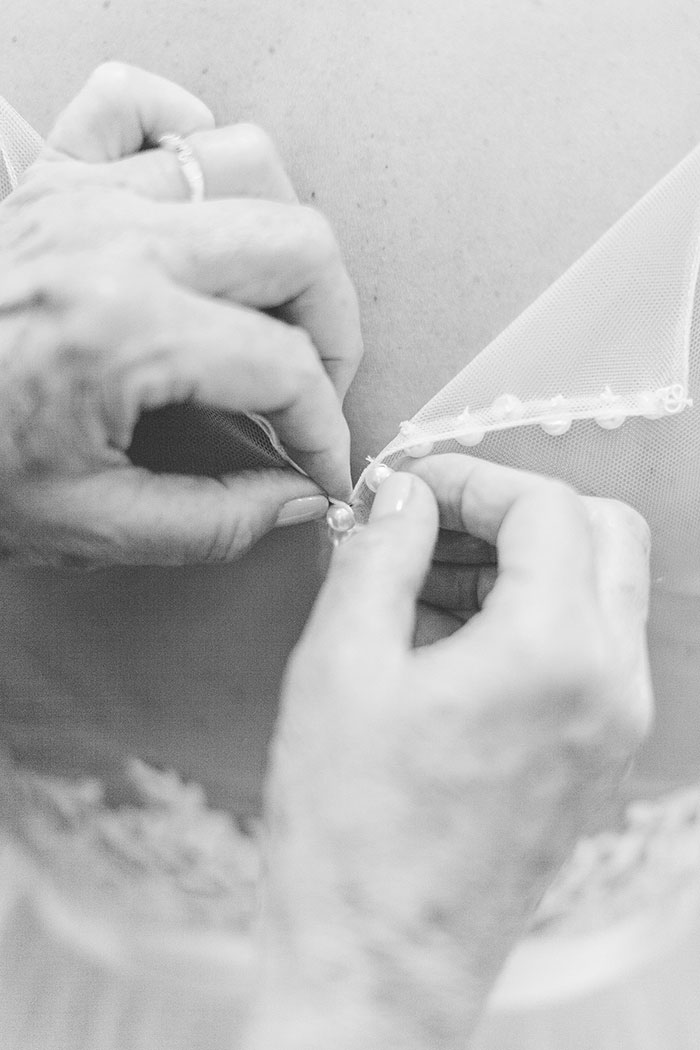 hands buttoning wedding dress