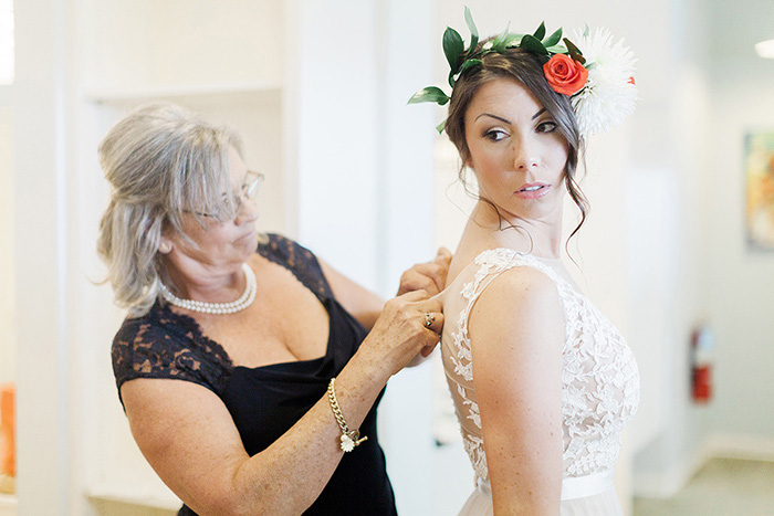 bride being buttoned into dress