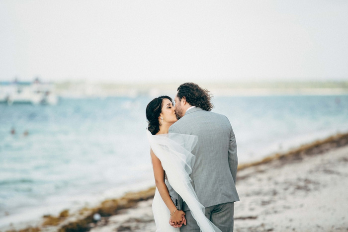 bride and groom kissing on beach