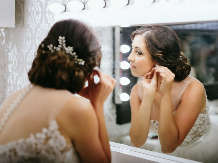 bride putting on earrings