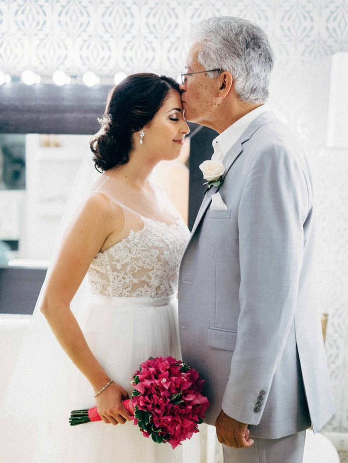 father of the bride kissing bride's forehead