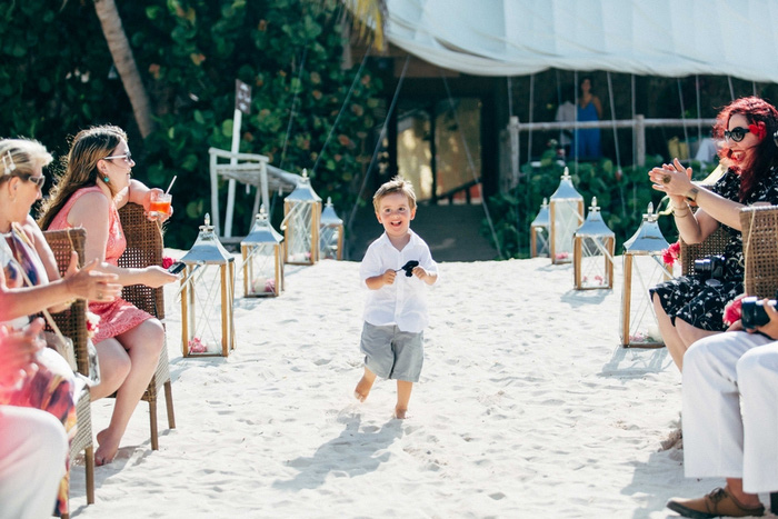 young ring bearer running down aisle