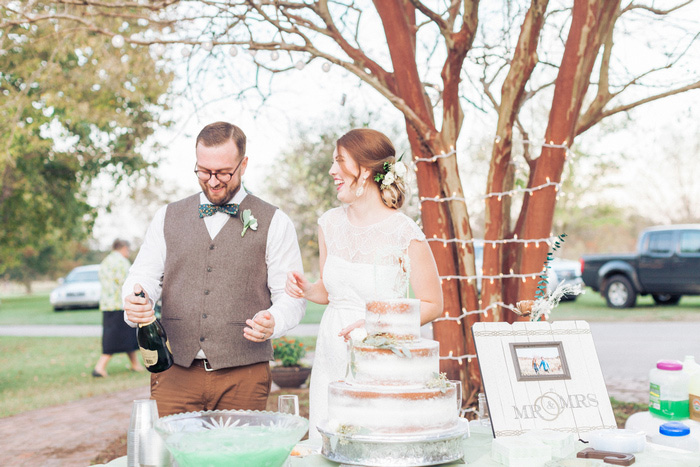 groom popping champagne bottle