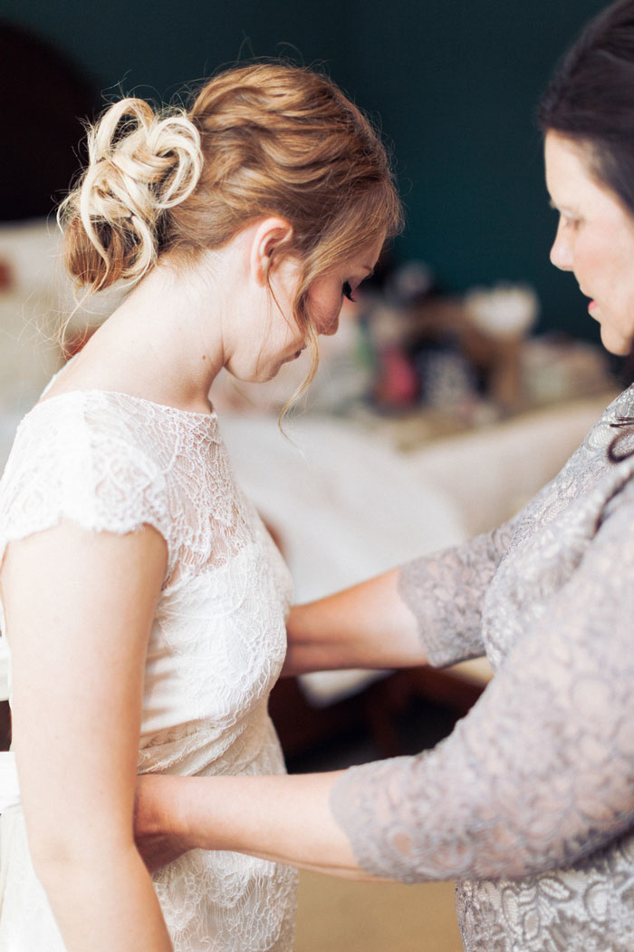 bride having bow tied other dress