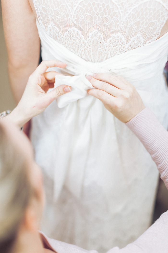 bride having bow tied other dress