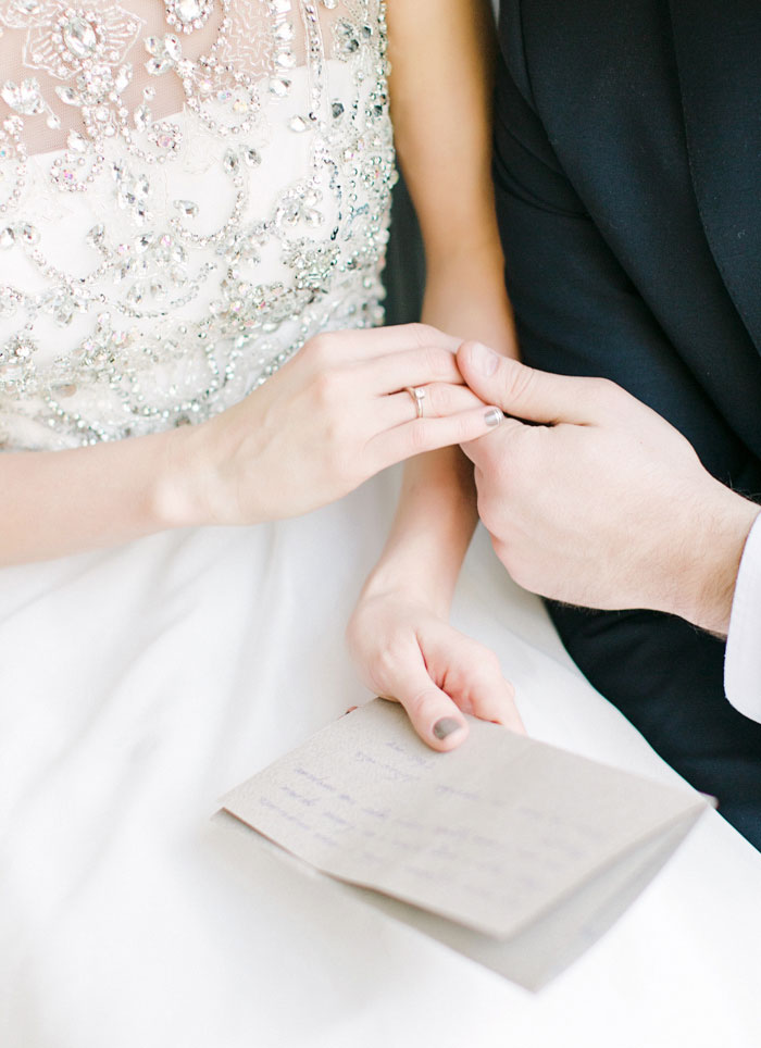 close-up of bride and groom holding hands