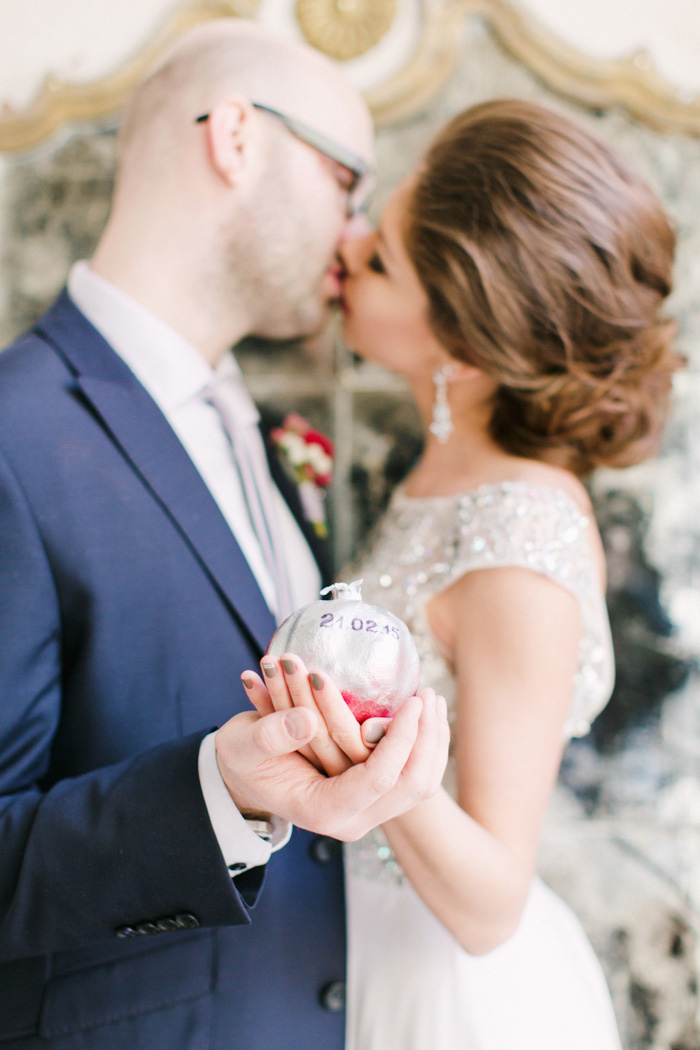 bride and groom holding pomegranate with wedding date