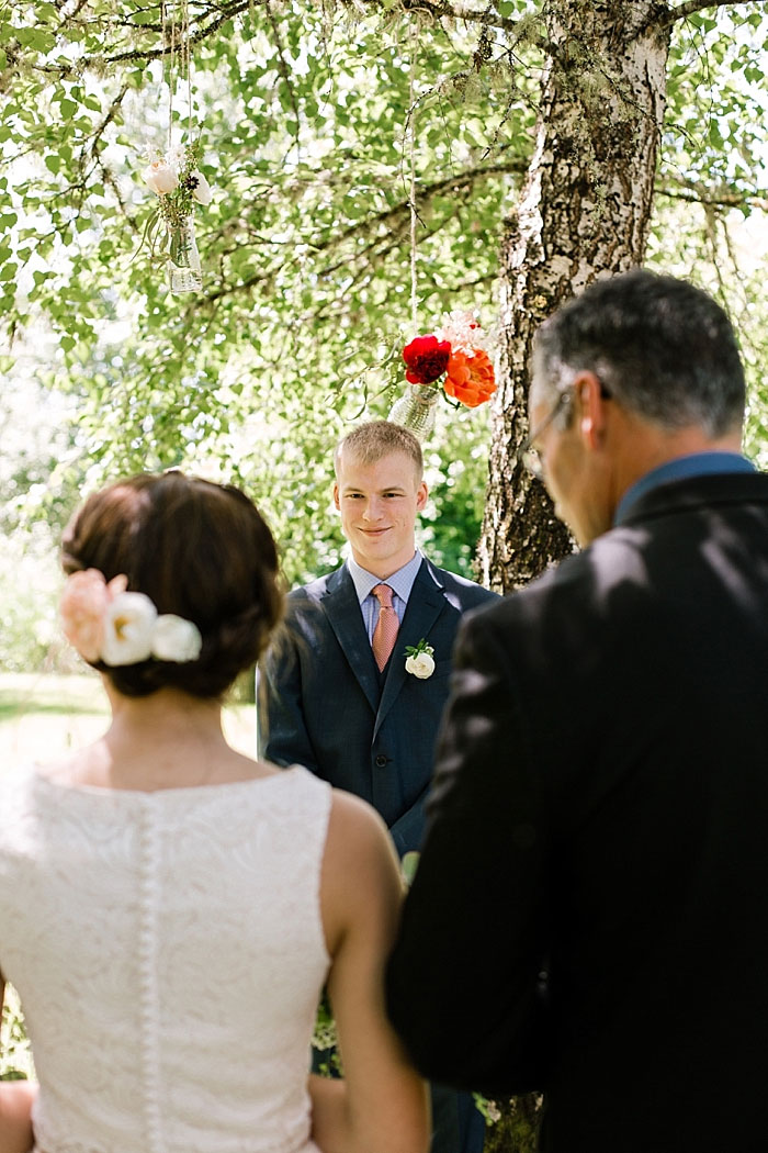 groom watching bride walk down the aisle