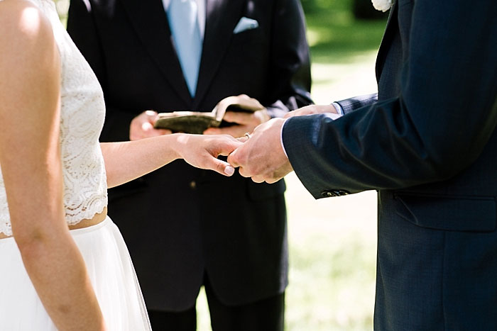 groom putting ring on bride's finger