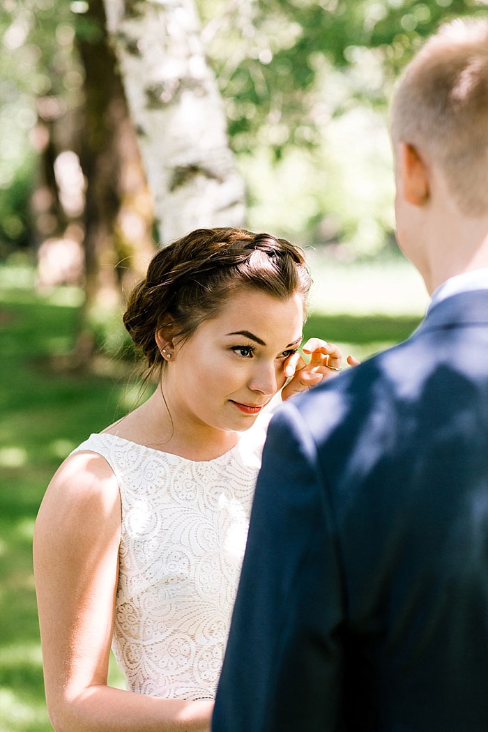 bride wiping away tear during ceremony