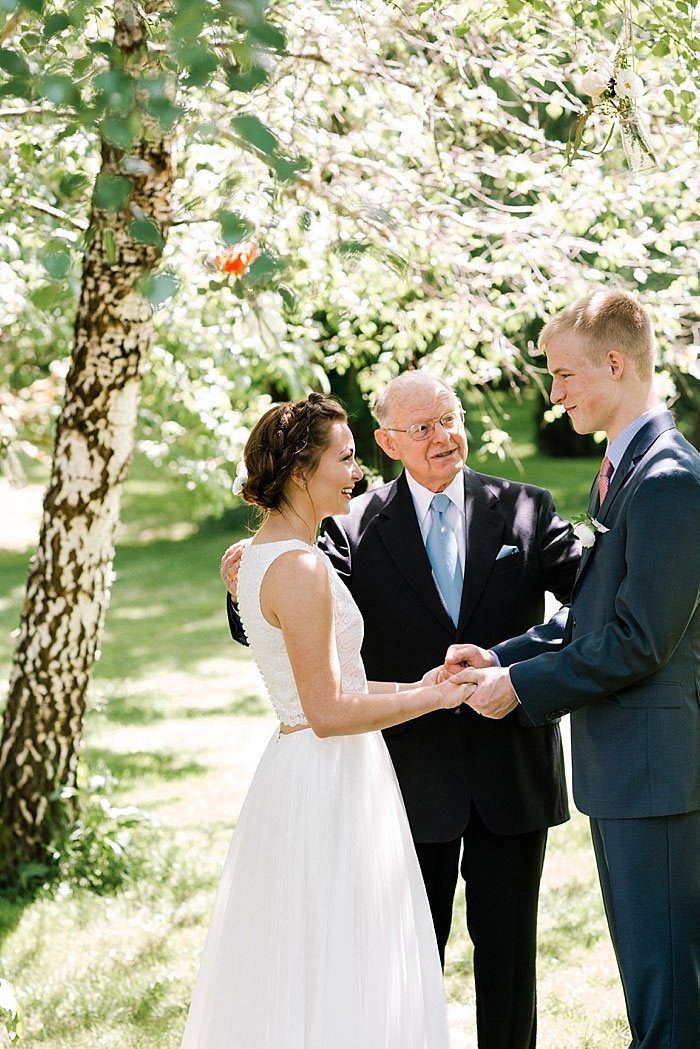 bride and groom holding hands during ceremony