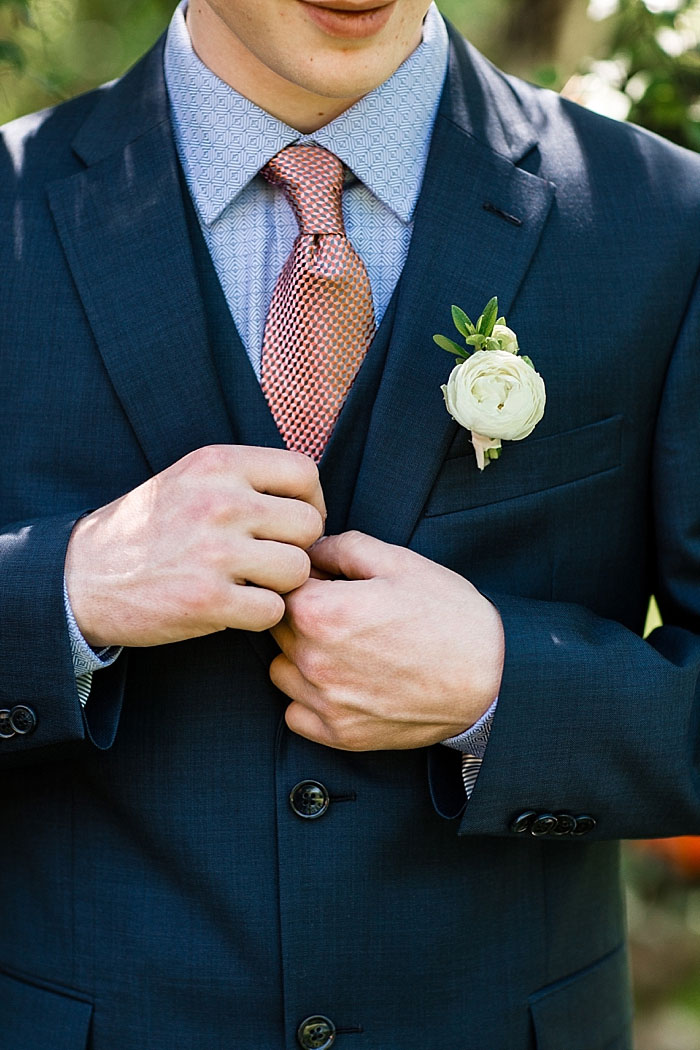 groom buttoning jacket