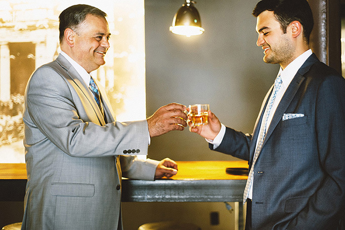 groom and father clinking glasses