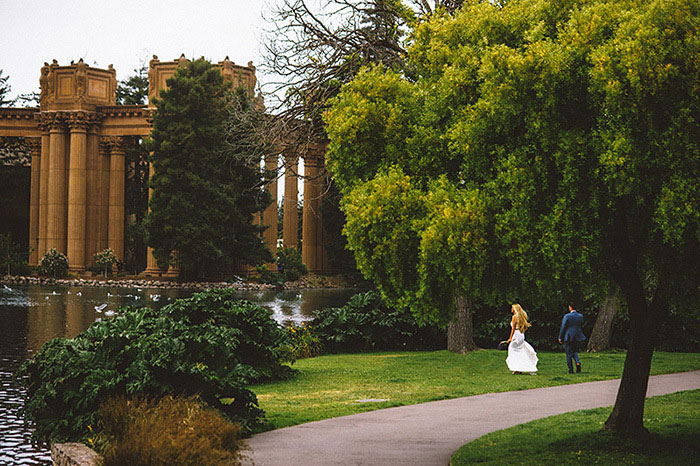 bride and groom asking through park