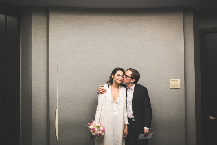 groom kissing bride on cheek