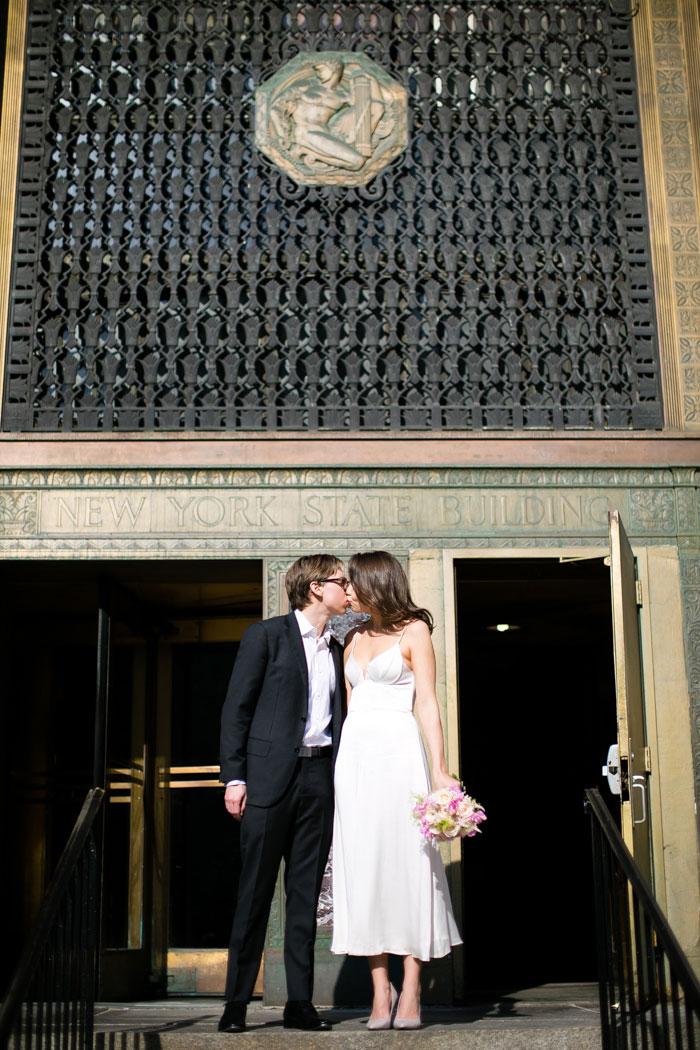 bride and groom kissing in front of city Hall