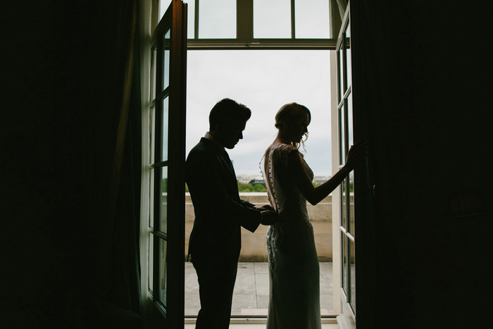 groom buttoning bride's dress