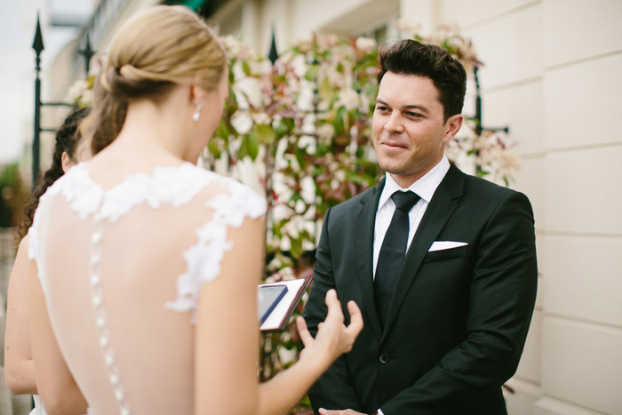 groom listening to bride recite vows