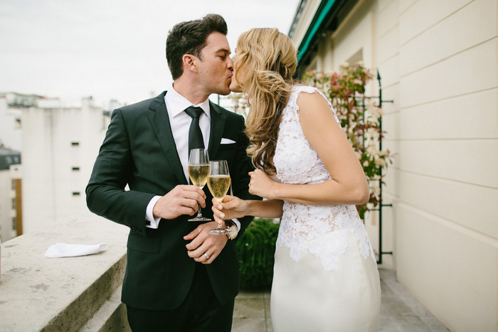 bride and groom kissing with champagne glasses